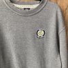 Detailed photo of the Bobby Orr Hall of Fame logo embroidered on the left chest of a grey sweatshirt.